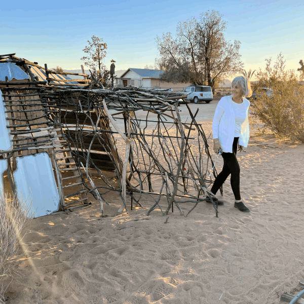 Woman exits stick assemblage sculpture