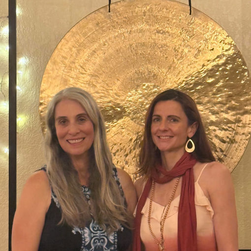 Jean and Moriah in front of a suspended hammered metal gong