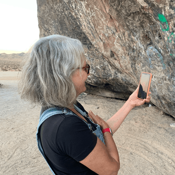 Woman views an AR exhibit on her smartphone at Giant Rock