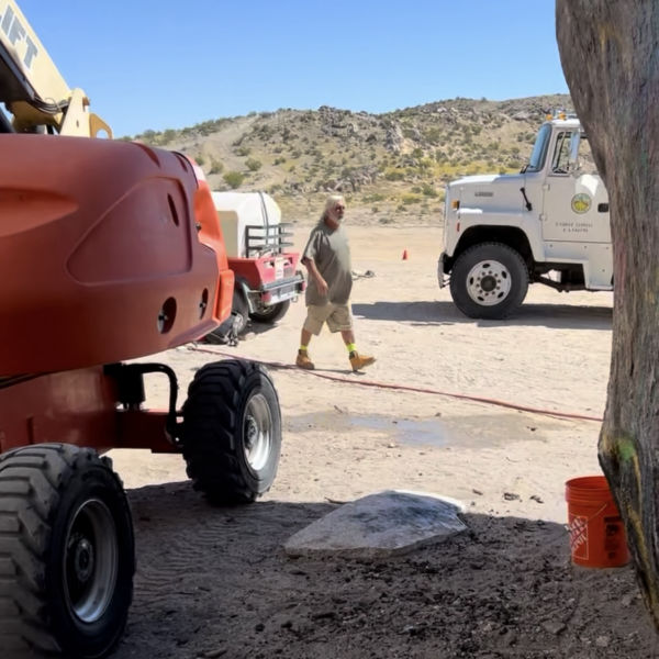 Man walks between heavy equipment
